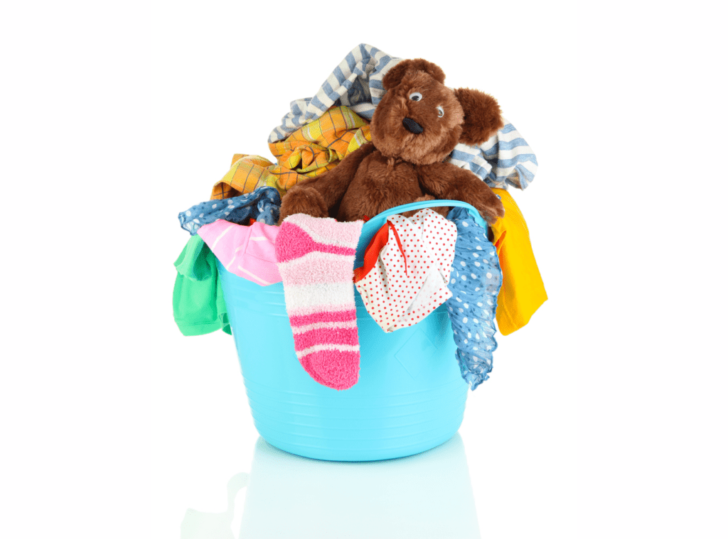 blue plastic laundry tub containing brightly coloured laundry including a confused looking teddy bear.