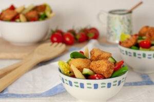 Crispy Salmon Bites on bed of brightly coloured mixed salad. Recipe from the eating well for eczema collection.