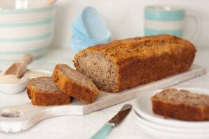 Eczema friendly and yummy banana bread, fresh out of the oven and sliced to show the heavy texture. Served on white plates.