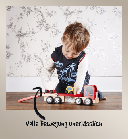 Kleiner Junge spielt mit einem Holzlastwagen, während er ScratchSleeves trägt, und zeigt, wie wenig diese Ekzem-Kratzhandschuhe die Bewegung und Geschicklichkeit einschränken